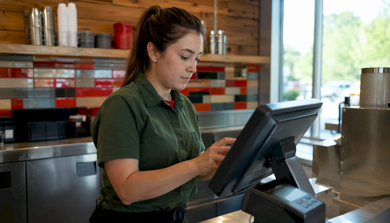 Hands using Wendy's digital menu touchscreen